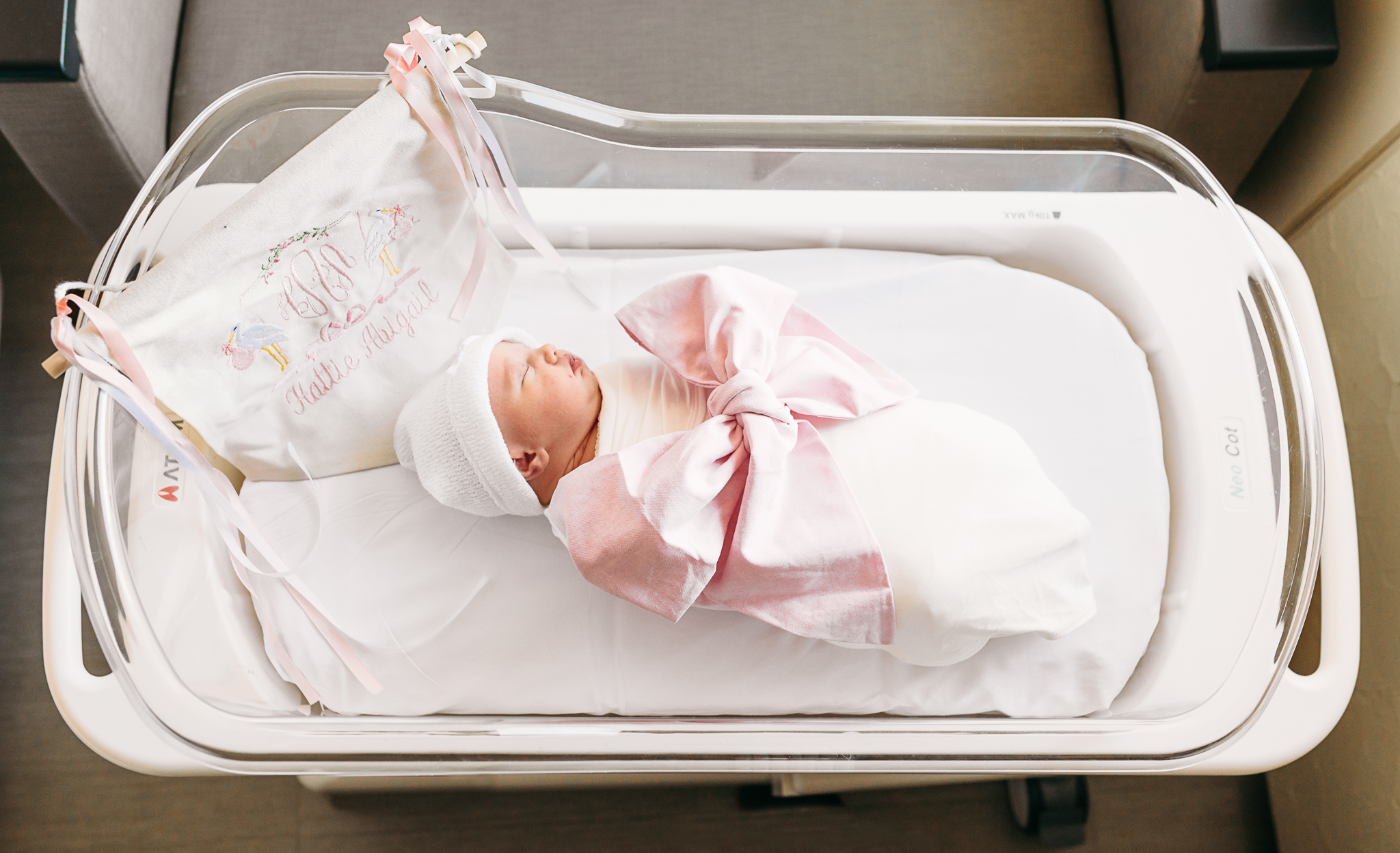 Baby lies in hospital crib during fresh 48 photo session.