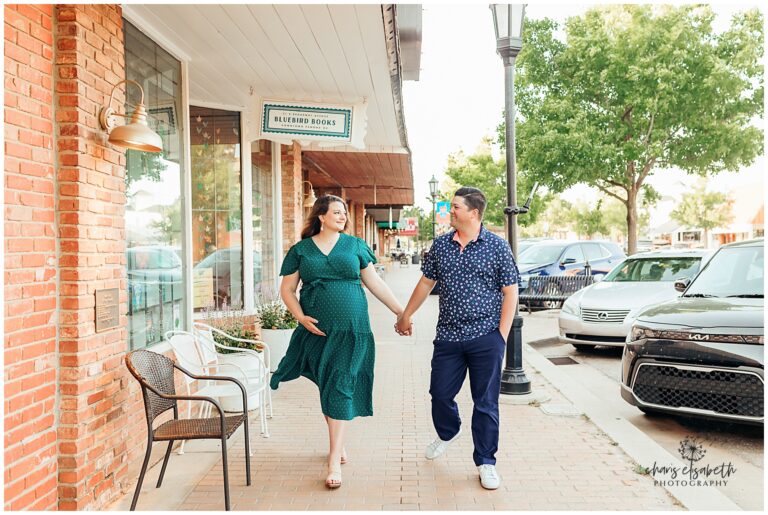 A couple walks in downtown Edmond OK during their maternity photo session.