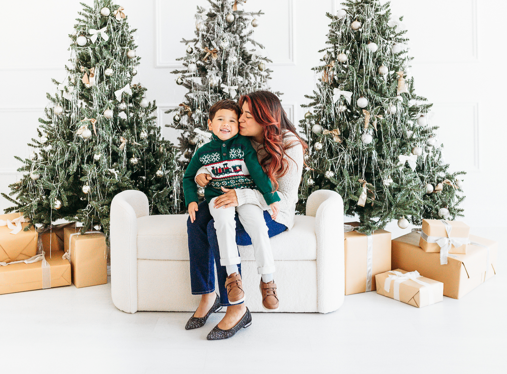 Mom and son sit in front of Christmas Trees in Edmond, OK studio.