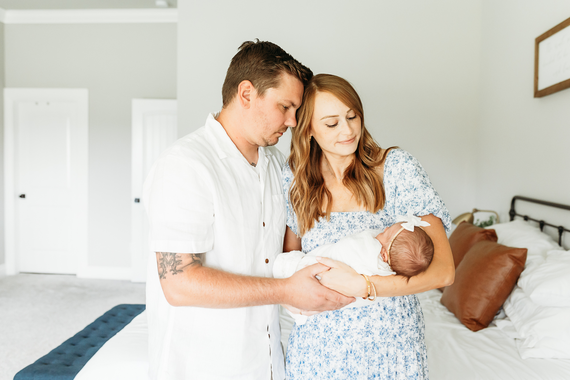 Mom and Dad hold newborn during photo session.