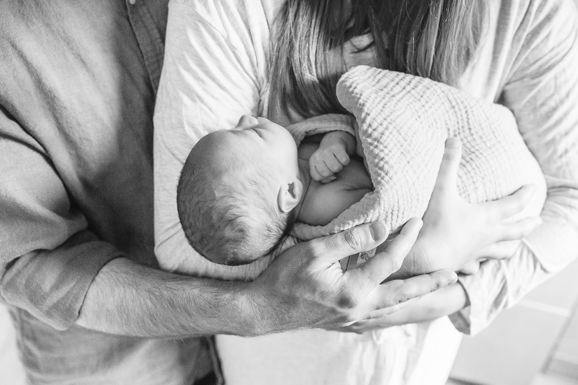 Baby in parents arms.