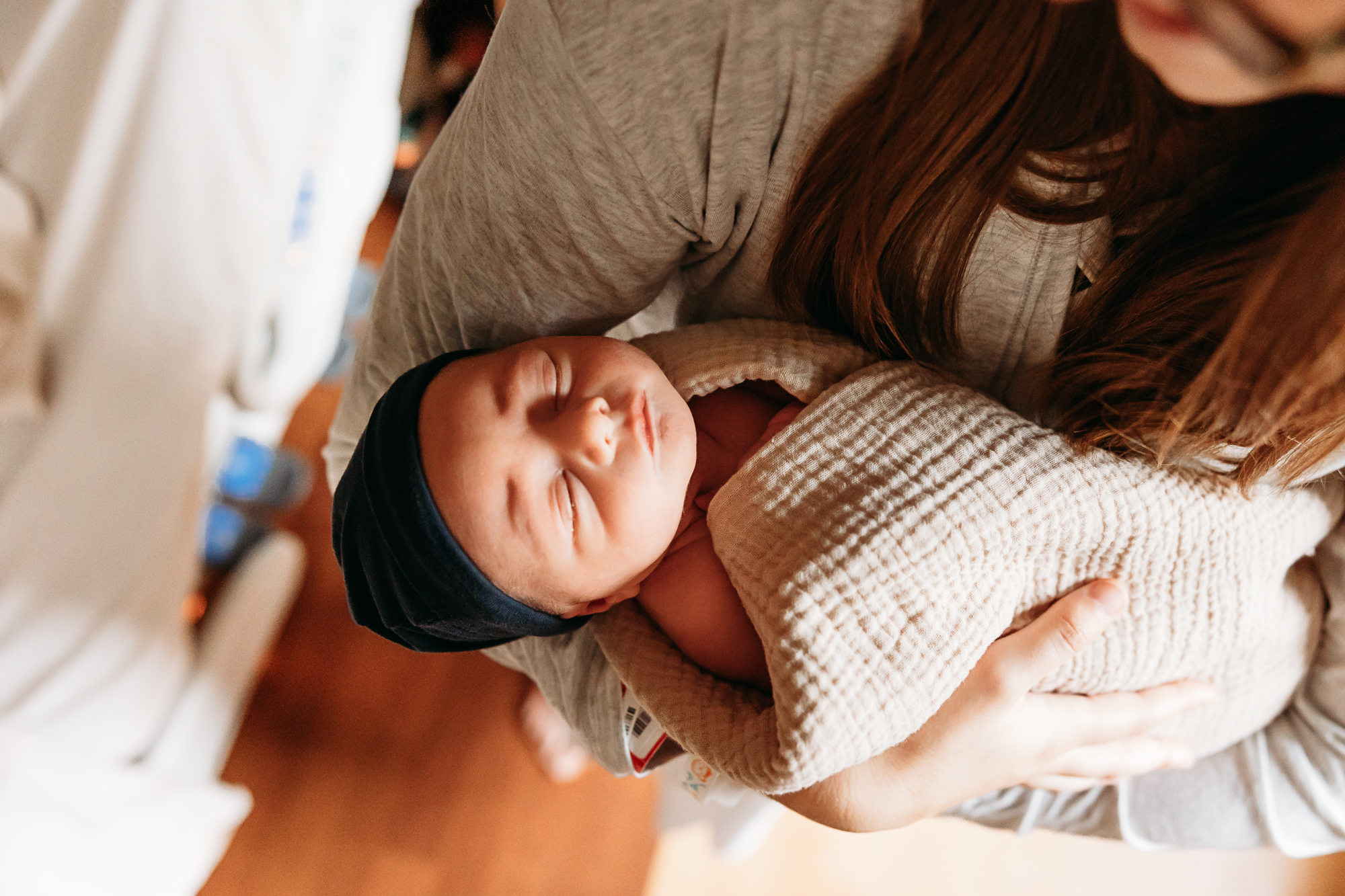 New baby in mother's arms during in hospital photo session.