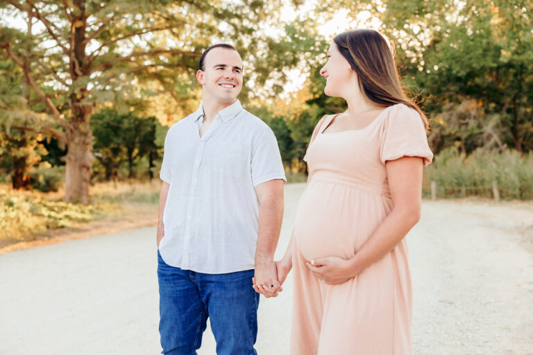 A couple doing maternity photos at Lake Hefner.