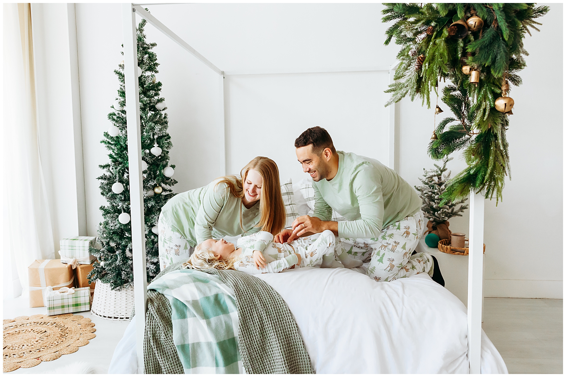 Family plays on bed during Christmas PJ mini sessions in Edmond, OK.